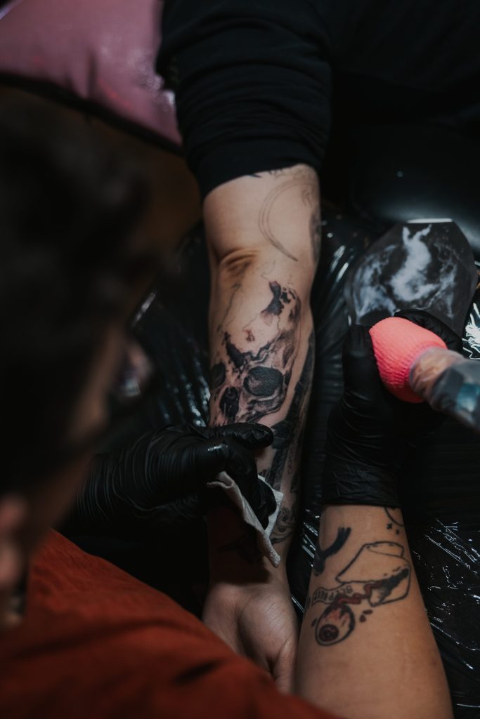 Aly tattooing an image from the videogame Bloodborne 